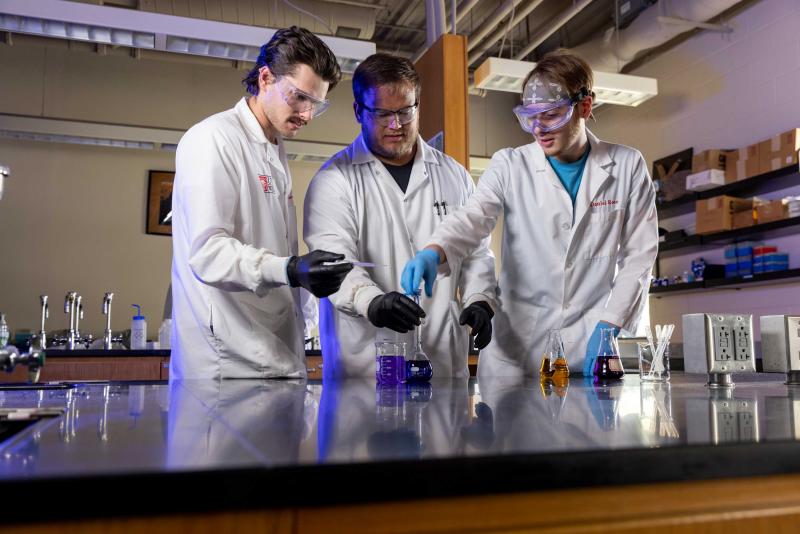 Three scientists work in a lab