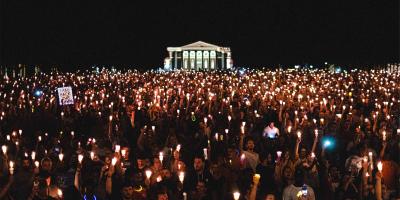 People gathered on UVA Lawn holding candles