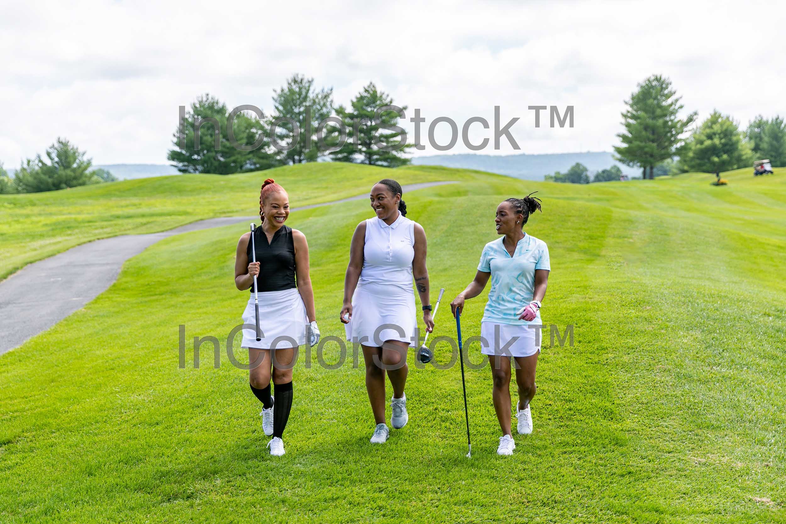 three women walking along the golf course