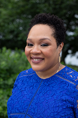 Yamiche Alcindor standing outside in a blue dress