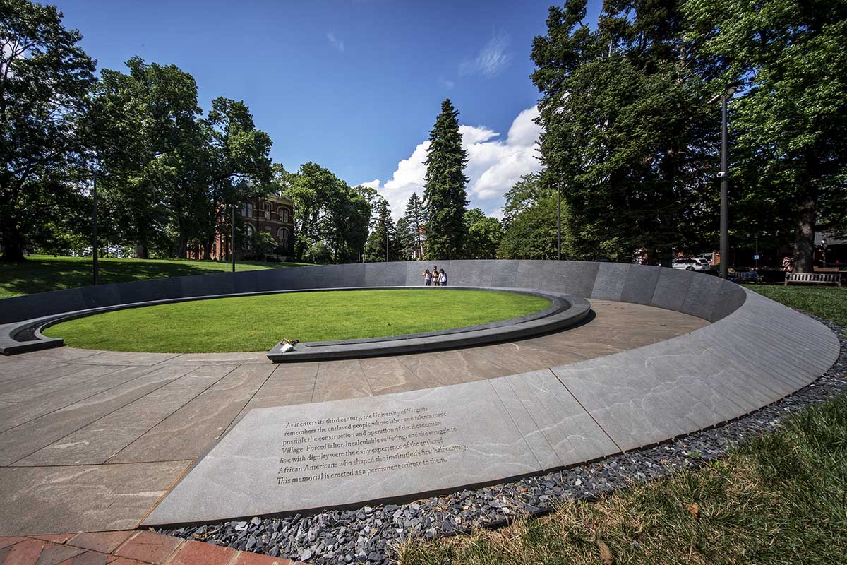 Image shows the entrance to the Memorial to Enslaved Laborers at UVA amidst backdrop of green trees