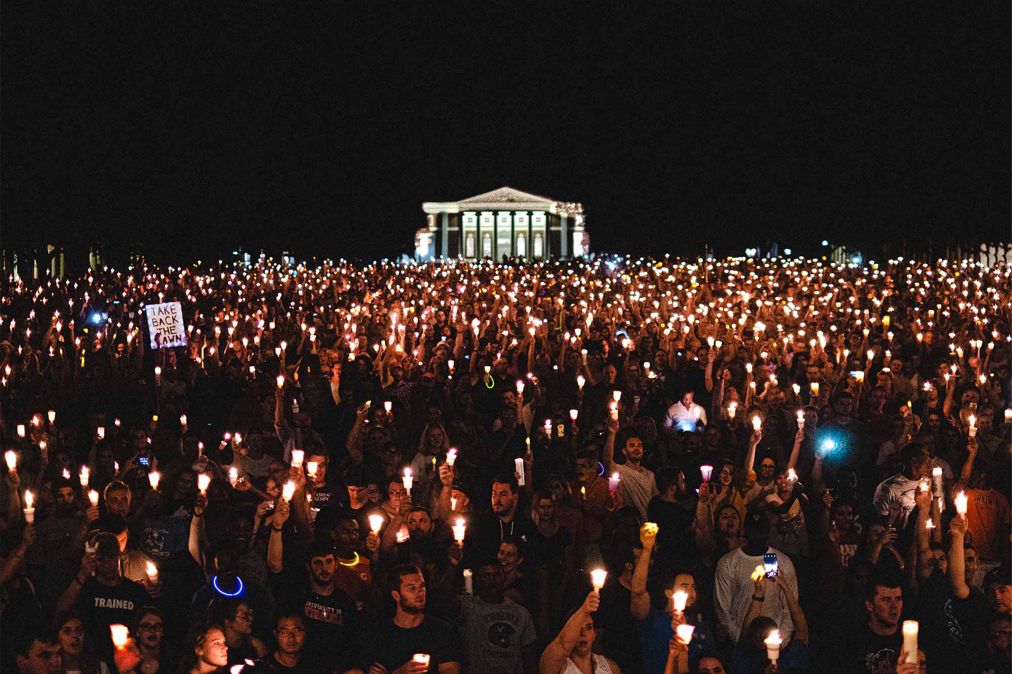 People gathered on UVA Lawn holding candles