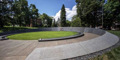 Image shows the entrance to the Memorial to Enslaved Laborers at UVA amidst backdrop of green trees